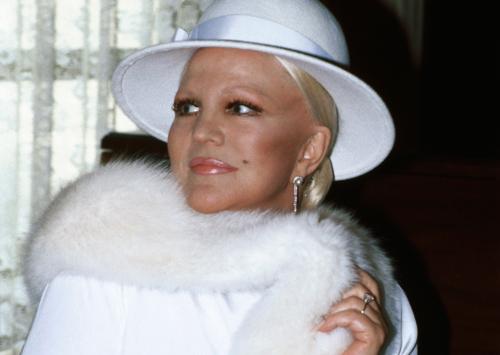 Peggy Lee in white, wearing a white hat and white animal fur stole